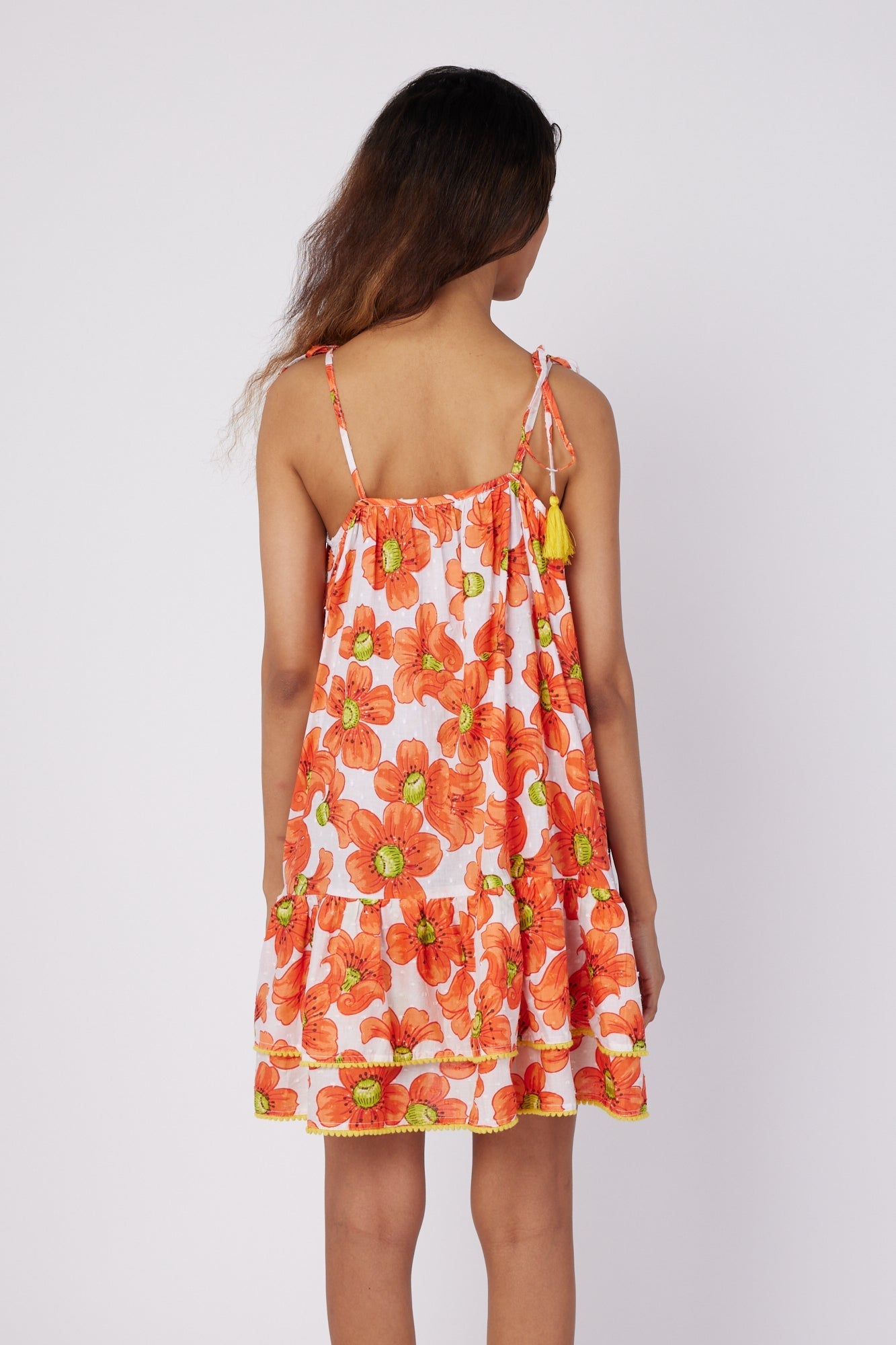 ModaPosa Tonia Sleeveless Spaghetti Strap Ruffle Mini Dress with Pom Pom Trim in Poppy . Discover women's resort dresses and lifestyle clothing inspired by the Mediterranean. Free worldwide shipping available!